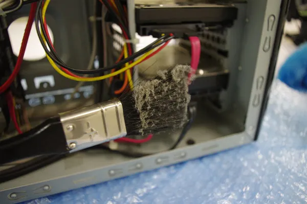 ハードディスクの上のホコリをハケで除去している様子